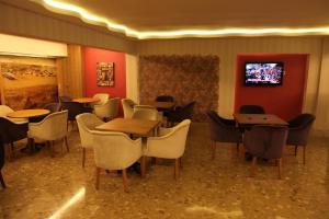 伊兹密尔Lucid Hotel酒店的一间带桌椅的餐厅以及墙上的电视