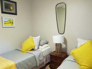 圣卢西亚圣卢西亚旅馆的一间卧室配有两张带黄色枕头和镜子的床