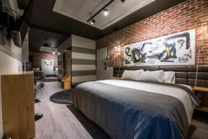 肖维尼根La Suite Hébergements的一间卧室设有一张大床和砖墙