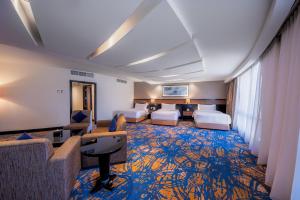 麦加Al Ghufran Safwah Hotel Makkah的酒店客房带两张床和一个客厅