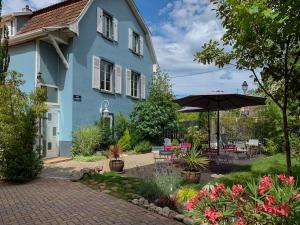 塞莱斯塔尚博勒斯迪霍特斯拉多马恩德斯勒姆帕尔斯酒店的蓝色的房子,配有遮阳伞和庭院