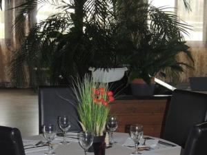 Grandvilliers莱托伊勒酒店的一张桌子,上面放着酒杯和植物