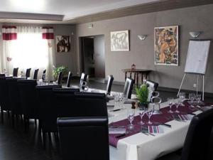 Grandvilliers莱托伊勒酒店的一间会议室,配有长桌子和椅子