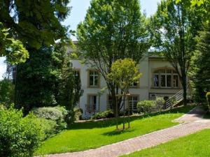南希勒克洛斯亚农酒店的一座大白色房子,在院子里种有树木
