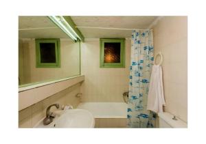 伊罗达Elounda Collection Apartments的一间带水槽、浴缸和镜子的浴室