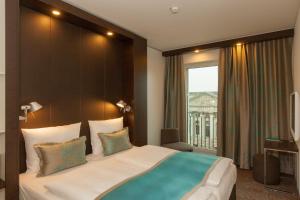 柏林柏林波茨坦广场一号汽车旅馆酒店的一间卧室设有一张大床和大窗户