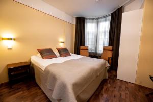 赫尔辛基亚瑟酒店的卧室配有一张带两个枕头的大白色床