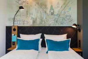 弗莱堡弗莱堡一号酒店的一间卧室配有一张带两个蓝色枕头的床