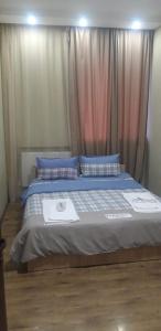 Marneuliкомфорт的一间卧室配有一张带蓝色枕头和窗帘的床
