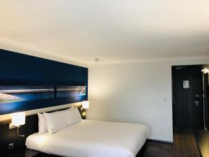 伯明翰皇冠假日伯明翰城市酒店&度假村的卧室配有白色的床和蓝色的墙壁