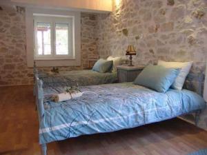 斯卡拉卡里拉奇斯Villa Valia的一间卧室设有两张床和石墙