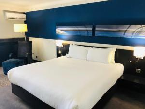 伯明翰皇冠假日伯明翰城市酒店&度假村的一间卧室配有一张白色大床和蓝色的墙壁