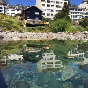 圣卡洛斯-德巴里洛切Berkana hostel Bariloche的水体中建筑物的反射