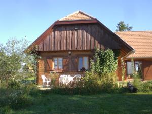 SzalafőNaturpark Ferienhaus的前面有两把白色椅子的房子