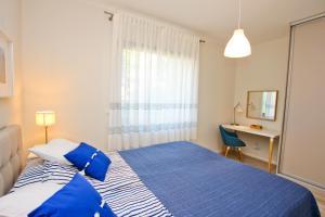 斯维诺乌伊希切visit baltic - Rezydencja Sienkiewicza Nautical apartment的卧室配有蓝色和白色的床和书桌。