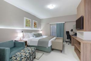 福塔莱萨福塔雷萨舒适酒店的酒店的客房 - 带一张床、椅子和电视
