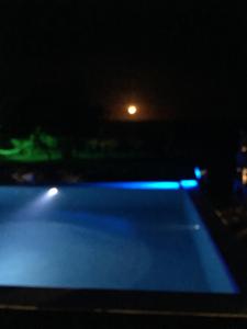阿拉亚尔达茹达Casa Grande São Vicente的夜晚的游泳池,灯光蓝色