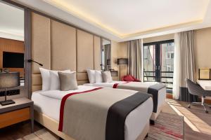 巴勒克埃西尔Ramada Residences by Wyndham Balikesir的酒店客房设有两张床和一个阳台。