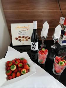 布莱顿霍夫不列颠思达戴酒店的一张桌子,上面放着一盘草莓和一瓶葡萄酒