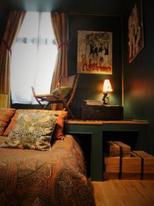 梅斯La Galerie-gîte的一间卧室配有一张床和一张带台灯的书桌