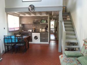 拉卡诺奥肯Tres agreable maison au calme dans la pinede的房屋内的厨房和用餐室,设有楼梯