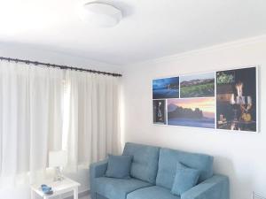 塔科龙特One bedroom appartement with sea view shared pool and furnished terrace at Tacoronte 4 km away from the beach的客厅设有蓝色的沙发和窗户。
