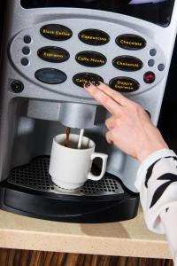 伦敦伊甸广场肯辛顿酒店的咖啡机里煮咖啡的人