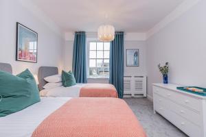 伍德斯托克Oxfordshire Living - The Spencer Apartment - Woodstock的一间卧室设有两张床和窗户。