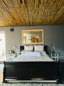 奥茨胡恩Die Kliphuisie的一间卧室设有一张带木制天花板的大床