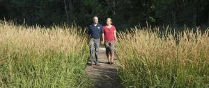 希博伊根Lake Orchard Farm Retreat的男人和女人走在高大的草地上