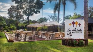 伊瓜苏港Pirayu Hotel & Resort的一组桌椅和遮阳伞