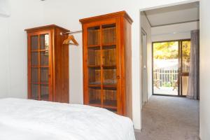 WaipapaGuinea's Rest的一间卧室配有一张床和一些玻璃橱柜
