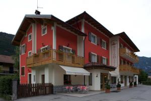 蒂奥内迪特伦托多洛米蒂索恩酒店的带阳台和桌子的红色建筑