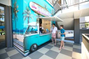 黄金海岸黄金海岸天堂度假村的两个人从冰淇淋车上订购食物