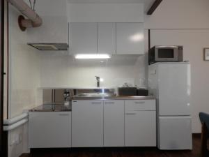 札幌Maple Sumikawa #201的厨房配有白色橱柜和微波炉
