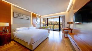 南京南京玄武湖假日酒店的卧室配有一张白色大床和电视。