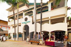 萨尤利塔Sayulita Central Hotel的棕榈树建筑前的商店