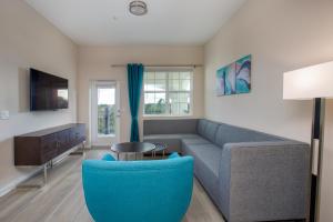 奥兰多Vista Cay Resort by Millenium at Universal Blvd.的带沙发和蓝椅的客厅