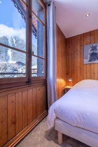 夏蒙尼-勃朗峰Chalet Clos 66的一间卧室设有一张床和一个大窗户