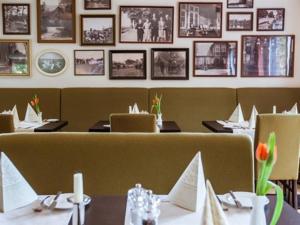 SecklendorfHotel-Restaurant Zur Linde的用餐室配有桌椅,墙上挂有图片