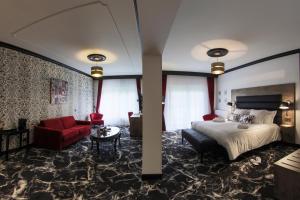 SauveterreHôtel du Barry Resort & Spa的酒店客房,配有一张床和一张红色的沙发