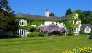 康威Glyn Isa Country House B&B and self catering Lodge的草坪上常春藤覆盖的房子