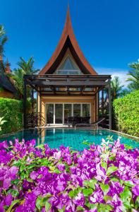 象岛象岛海滩别墅的一座带紫色花的游泳池的房子