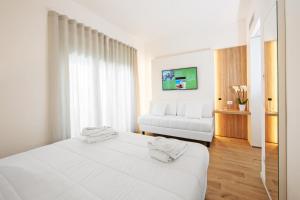 蒂勒尼亚Toscana Charme Resort的白色卧室配有床和沙发