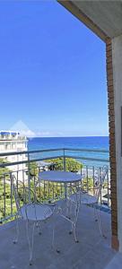 阿拉西奥residence cristallo的俯瞰大海的阳台配有桌椅