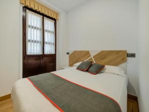 安普埃罗Hostal Restaurante La pinta的卧室设有一张白色大床和一扇窗户。