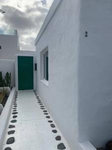 法马拉Casa Callao的白色的建筑,设有绿门和人行道