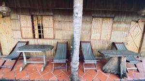 永隆mekong riverside homestay的一张桌子和椅子,坐在大楼前