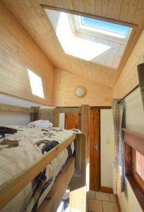 JarrierLe Petit Chalet-Leard的一间卧室配有一张床和天窗