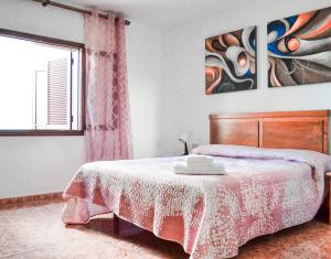 洛斯克里斯蒂亚诺斯Banana Surf House的一间卧室配有一张带木制床头板的床和窗户。